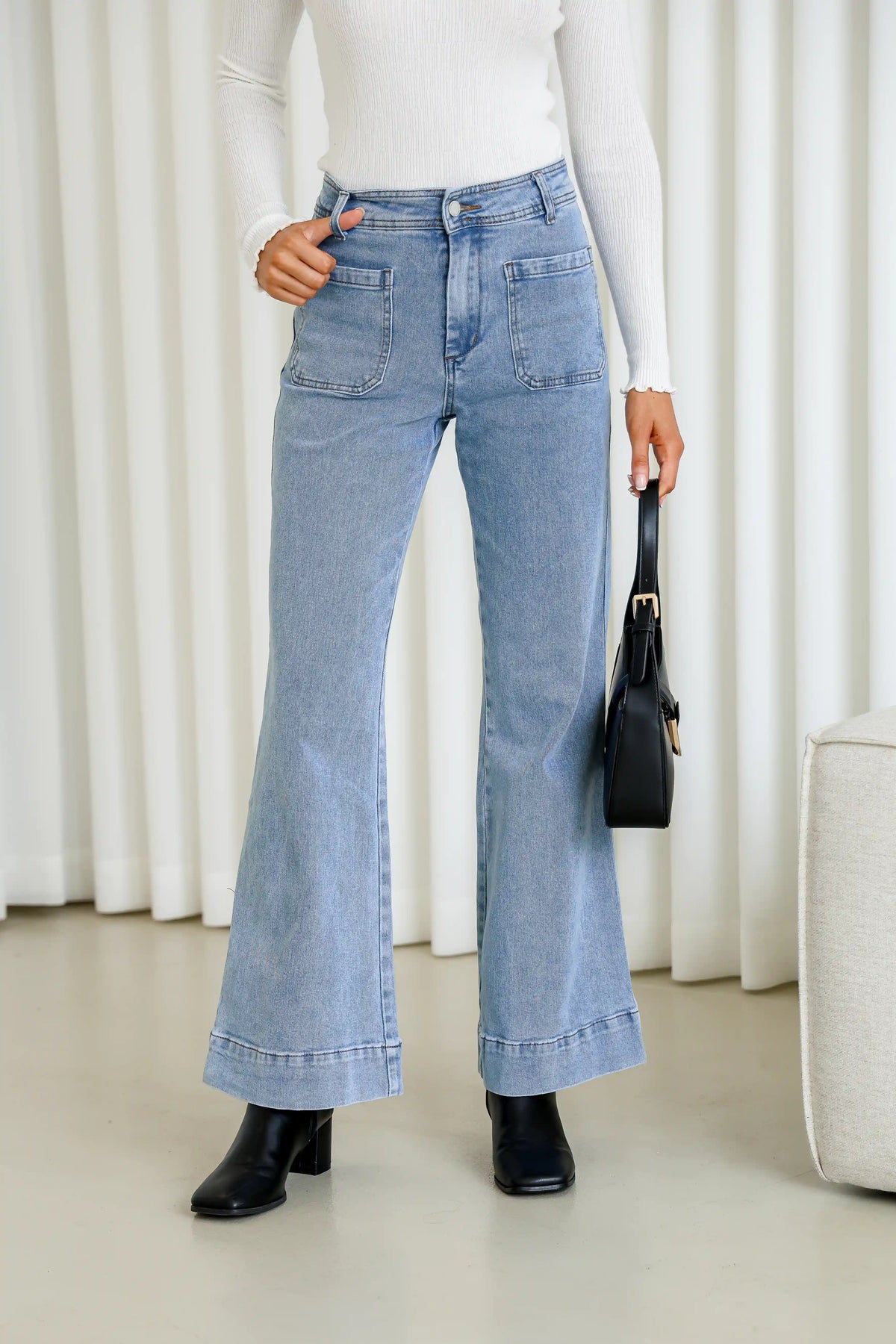 Sailor Wide Leg Pocket Jeans light blue – model with thumb in belt loop styled shot